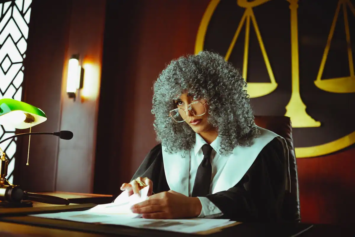 Judecător care examinează actele dosarului sub o lampă verde de birou