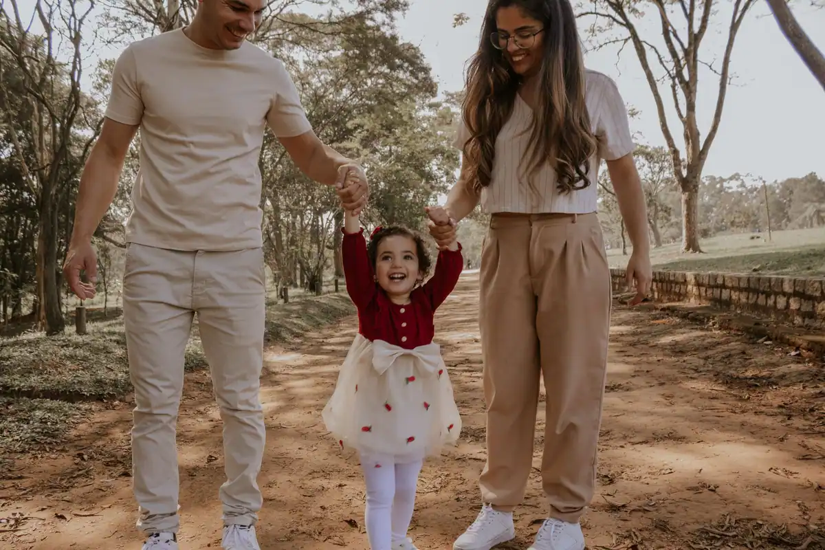 Familie fericită care se plimbă prin parc, părinți și copii împreună