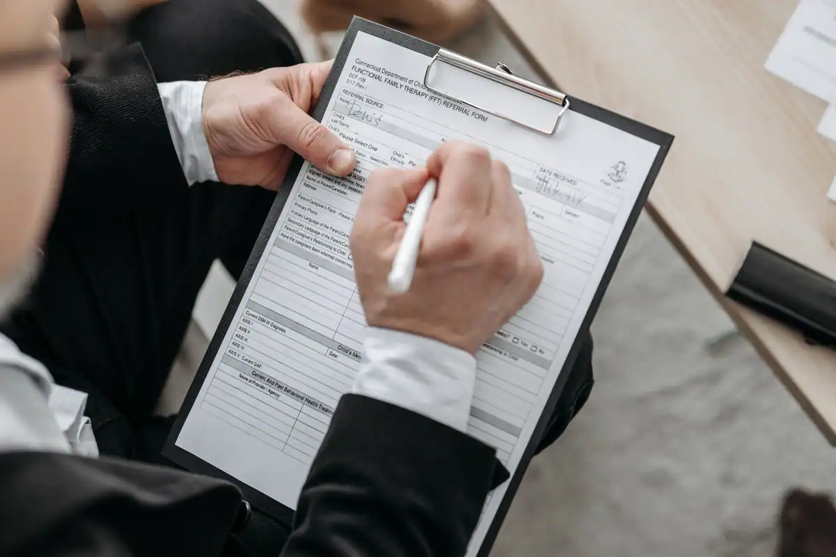 Om de afaceri care semnează un formular prins pe clipboard pentru o cerere mică