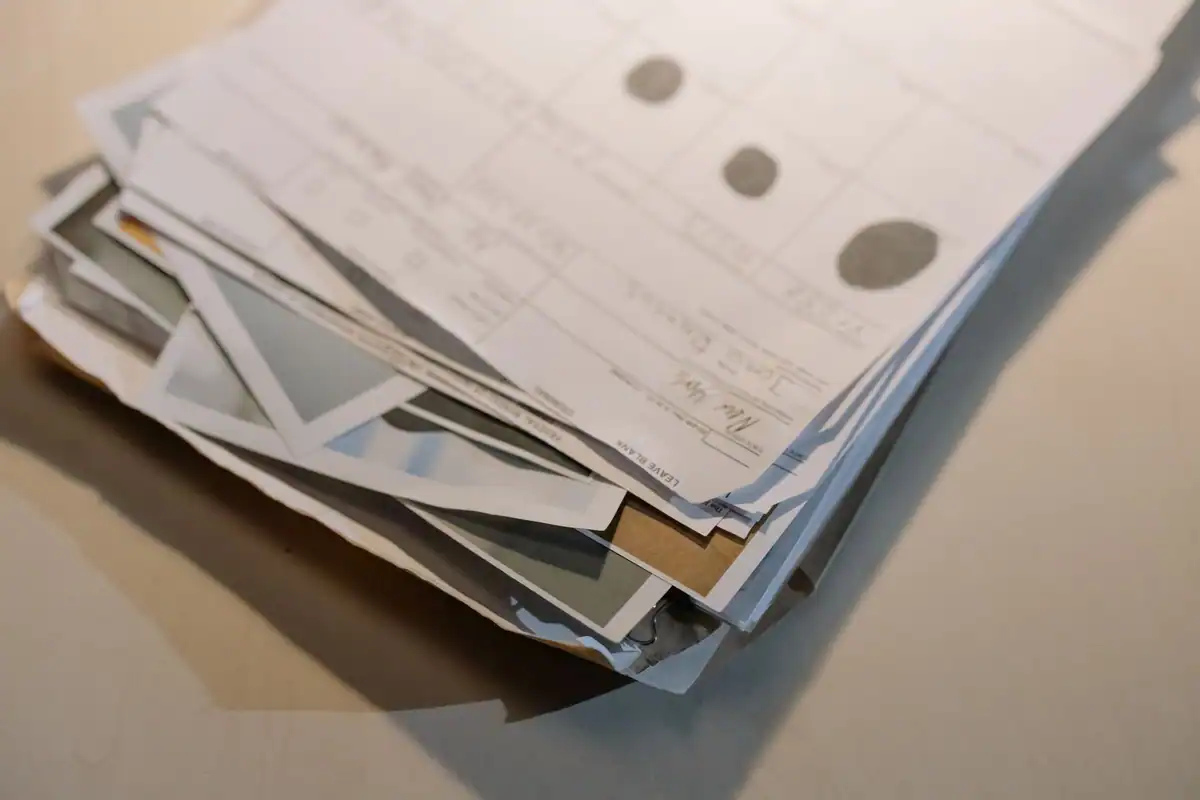 Teanc de hârtii și documente vechi pe un birou, acte cu termene de verificat