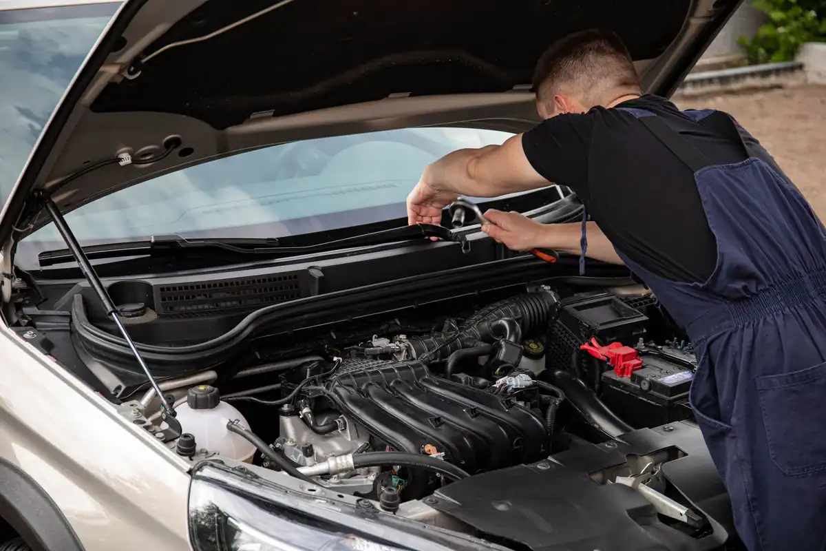 Mecanic care repară motorul unei mașini cumpărate la mâna a doua